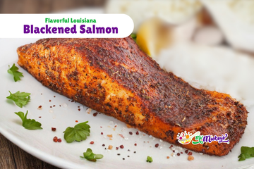 A seasoned, pan-seared blackened salmon fillet on a white plate, garnished with fresh parsley and coarse salt.